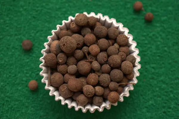 Tahta kaşıkla kasede siyah kahve çekirdekleri.