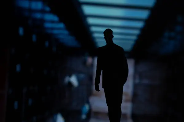 Karanlık odada bir adamın silueti.