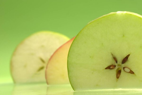 свежее зеленое яблоко с капельками воды на белом фоне