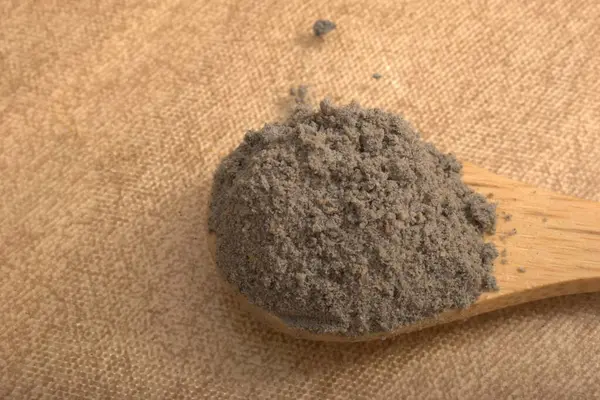 Yakın plan - Tahta bir arka planda kahverengi şeker tozu kepçesinin görüntüsü.