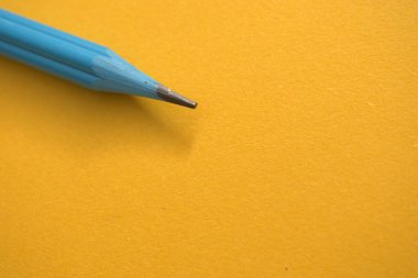 Kağıdın üzerinde mavi kalem olan sarı kalem.