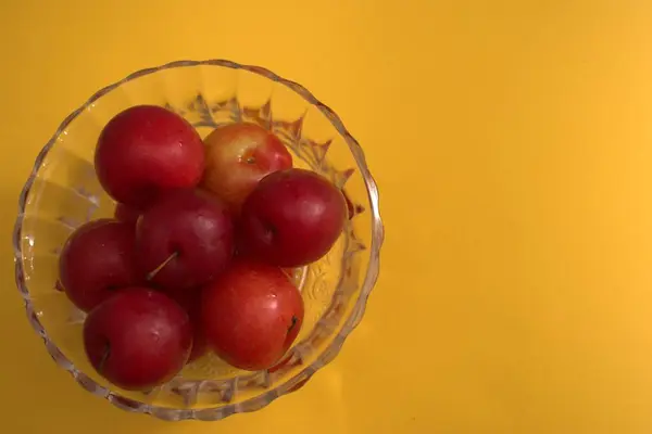 Sarı zemin üzerine kırmızı elmalar.