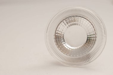 Dairesel LED spot ışığı yansıtıcısının minimalist fotoğrafı ya da temiz beyaz arka planda optik lens. Ürün kataloglarında, teknoloji makalelerinde, elektronik sunumlarda veya endüstriyel tasarım modellerinde kullanım için ideal.