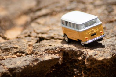 Sarı arka planı olan oyuncak araba.