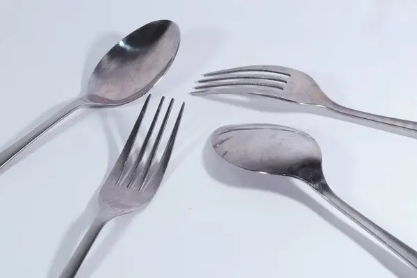 Beyaz arkaplanda paslanmaz kaşık ve çatal