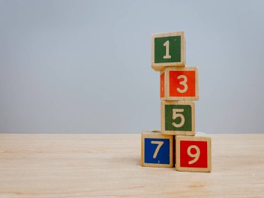 Ahşap masa üzerinde numarası olan renkli tahta küp oyuncakları arka plan olarak kullanılabilir.