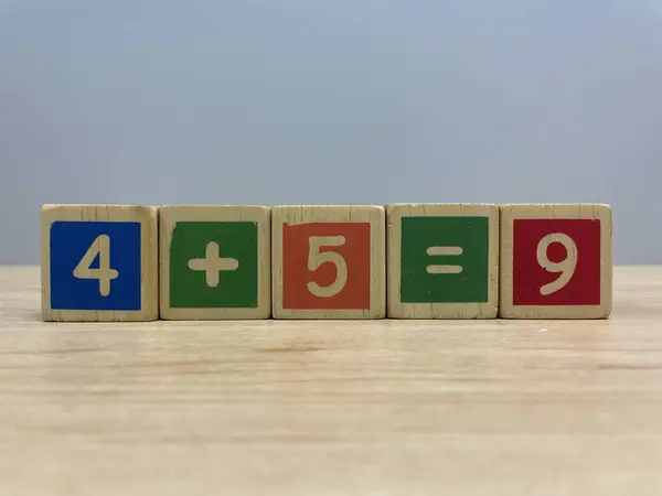 Ahşap masa üzerinde numarası olan renkli tahta küp oyuncakları arka plan olarak kullanılabilir.