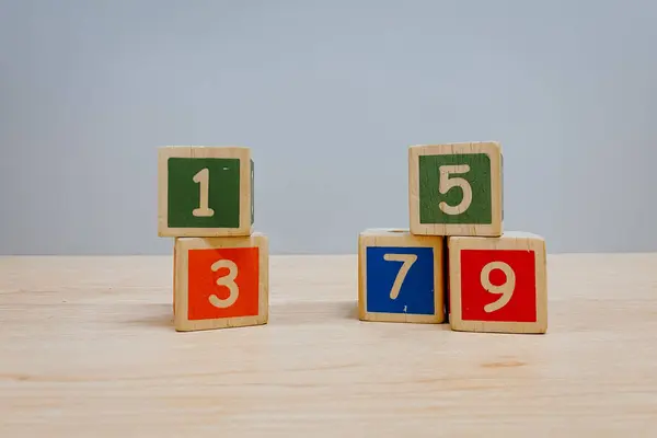 Ahşap masa üzerinde numarası olan renkli tahta küp oyuncakları arka plan olarak kullanılabilir.
