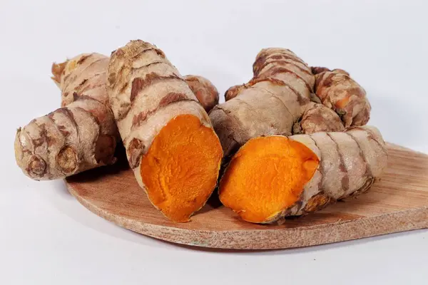 Ahşap zeminde taze zerdeçal ve ahşap arka planda