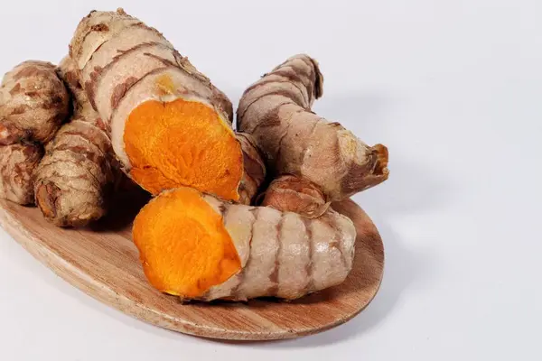 Tahta zeminde taze zerdeçal ve beyaz arkaplan