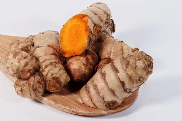 Tahta zeminde taze zerdeçal ve beyaz arkaplan