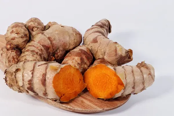 Tahta zeminde taze zerdeçal ve beyaz arkaplan