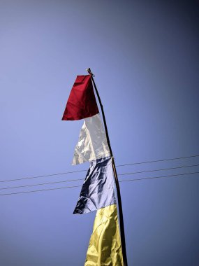 Mavi gökyüzünde renkli bayraklar Bambu direkleri üzerinde dalgalanıyor