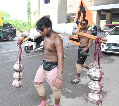 NEW DELHI, INDIA - JULY 25, 2024: Aakash Kumar devotees popularly known as Kanwariyas carry Lord Shiva statue and Ganga water at Shahdara in New Delhi, India. On Thursdays, July 25, 2024. Kanwariyas carries water from the holy river to their  clipart