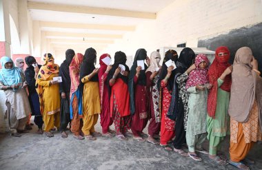 GURUGRAM, INDIA - 25 Mayıs 2024 'te Hindistan' ın Gurugram kentindeki Ghasera köyünde yapılan Lok Sabha seçimlerinin altıncı safhasında oy kullanmak için bir sandık kulübesinin önünde bekleyenler var. Genel seçimlerin altıncı safhası için yapılan anket sonuçlandı 