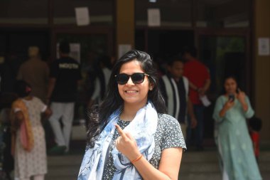 GURUGRAM, INDIA - 25 Mayıs 2024 'te Hindistan' ın Gurugram kentinde, Sohna karayolu sektörü 49 'da yapılan bir apartman dairesinde, Lok Sabha seçimlerinin altıncı safhasında, mürekkepli parmağını şaklatan bir kadın oyunu kullandı.. 