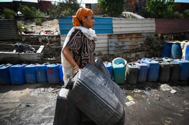 NEW DELHI, INDIA - 30 Mayıs 2024: 30 Mayıs 2024 'te Yeni Delhi, Hindistan' da Anand Parbat 'ta su krizi sırasında Delhi Jal Tahta Tankeri' nden su dolduran insanlar görüldü