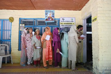 SRINAGAR, INDIA - 25 Mayıs 2024: İnsanlar Srinagar 'ın güneyindeki Khundroo bölgesinde yapılan Lok Sabha seçimlerinin altıncı safhasında, 25 Mayıs 2024' te Hindistan 'ın Srinagar kentinde oy kullanmak için sırada bekliyorlar.