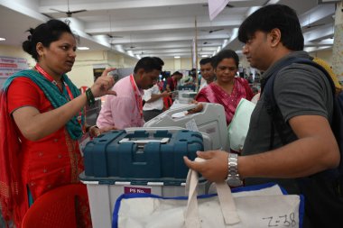 NAVI MUMBAI, INDIA - 18 Mayıs 2024: Seçim görevlileri, 20 Mayıs 2024 tarihinde Hindistan 'ın Navi Mumbai kentinde yapılacak Agri Koli Bhavan Nerul' da seçim için bir seçim sandığı taşıyorlar..