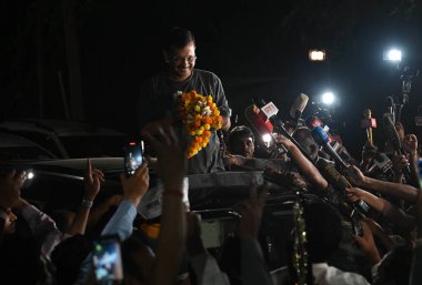 Delhi CM Arvind Kejriwal, 10 Mayıs 2024 'te Hindistan' ın başkenti Yeni Delhi 'de ikamet ettiği yerin önünde geçici kefaletle serbest bırakıldıktan sonra destekçilerine sesleniyor..