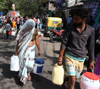 NEW DELHI, INDIA - 31 Mayıs 2024: Delhi Jal Board (DJB) su tankeri sakinleri ve çocukları, Vivekananda Kamp Chanakyapuri 'de yaz aylarında yaşanan bir su krizinin ortasında, 31 Mayıs 2024 tarihinde, Hindistan' ın Yeni Delhi kentinde.