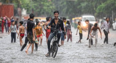 NEW DELHI, INDIA - 27 Temmuz 2024 'te, Hindistan' ın Yeni Delhi kentinde, 27 Temmuz 2024 'te, şehir merkezi yakınlarındaki su dolu bir Tagore Yolu' nda oynayan çocuklar. 