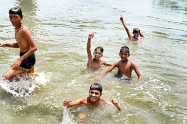 NEW DELHI, INDIA - 30 Mayıs 2024 Perşembe günü Doğu Delhi 'de Ghazipur drenajı' nda erkekler serinliyor.. 