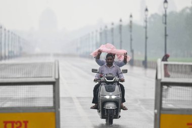 NEW DELHI, INDIA - 27 Temmuz 2024 'te Hindistan Kapısı' nda aniden yağan yağmurlar sırasında Yeni Delhi, Hindistan 'da insanlar görüldü..