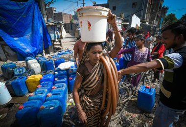 NEW DELHI, INDIA - 30 Mayıs 2024: 30 Mayıs 2024 'te Yeni Delhi, Hindistan' da Anand Parbat 'ta su krizi sırasında Delhi Jal Tahta Tankeri' nden su dolduran insanlar görüldü