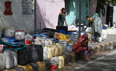 NEW DELHI, INDIA - 29 Mayıs 2024 'te Hindistan' ın Yeni Delhi kentinde, Viveknand Camp Chanakyapuri 'de, yaz aylarında bir su krizi sırasında, bir tankerden içme suyu bekleyen yerliler. Artan sıcaklıkla Delhi büyük bir su kriziyle karşı karşıya.