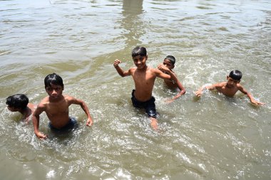 NEW DELHI, INDIA - 30 Mayıs 2024 Perşembe günü Doğu Delhi 'de Ghazipur drenajı' nda erkekler serinliyor.. 