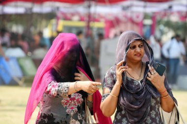 26 Mayıs 2024 'te Hindistan' ın Gurugram şehrinde, Hükümet Kızlar Koleji 'nde sıcak bir yaz gününde sıcak hava dalgasından korunmak için başınızı ve yüzünüzü örtüye saran insanlar görülüyor.. 