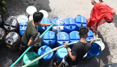 NEW DELHI, INDIA - 29 Mayıs 2024 'te Hindistan' ın Yeni Delhi kentindeki Sanjay Camp Chanakyapuri 'de yaz aylarında yaşanan bir su krizi sırasında, yerliler bir tankerden içme suyu alıyorlar. Artan sıcaklıkla Delhi büyük bir su kriziyle karşı karşıya. 