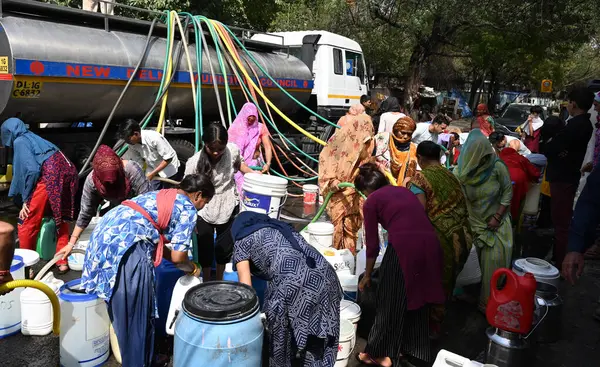 NEW DELHI, INDIA - 31 Mayıs 2024: Delhi Jal Board (DJB) su tankeri sakinleri ve çocukları, Vivekananda Kamp Chanakyapuri 'de yaz aylarında yaşanan bir su krizinin ortasında, 31 Mayıs 2024 tarihinde, Hindistan' ın Yeni Delhi kentinde. 