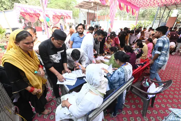 Stock image NEW DELHI, INDIA - MAY 25, 2024: Voters check their names in voter List during Lok Sabha election 2024, at polling station, at Civil Line area, on May 25, 2024 in New Delhi, India.