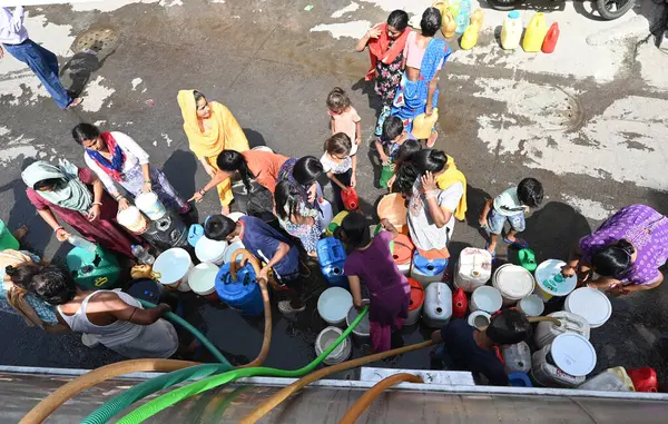 NEW DELHI, INDIA - 29 Mayıs 2024 'te Hindistan' ın Yeni Delhi kentindeki Sanjay Camp Chanakyapuri 'de yaz aylarında yaşanan bir su krizi sırasında, yerliler bir tankerden içme suyu alıyorlar. Artan sıcaklıkla Delhi büyük bir su kriziyle karşı karşıya. 