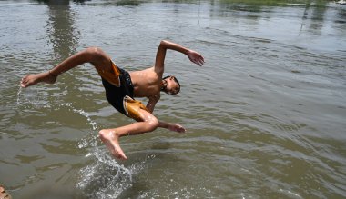 NEW DELHI, INDIA - 30 Mayıs 2024 Perşembe günü Doğu Delhi 'de Ghazipur drenajı' nda erkekler serinliyor.. 