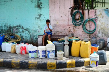 NEW DELHI, INDIA - 29 Mayıs 2024: Chanakyapuri 'deki JJ Cluster Vivekanand Kolonisi sakinleri 29 Mayıs 2024' te Yeni Delhi, Hindistan 'da bir tankerden su doldurdular. 