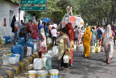 NEW DELHI, INDIA - 31 Mayıs 2024: Delhi Jal Board (DJB) su tankeri sakinleri ve çocukları, Vivekananda Kamp Chanakyapuri 'de yaz aylarında yaşanan bir su krizinin ortasında, 31 Mayıs 2024 tarihinde, Hindistan' ın Yeni Delhi kentinde.