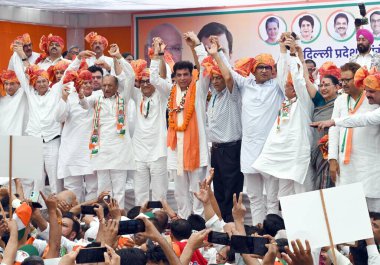 NEW DELHI, INDIA - MAY 5, 2024: DPCC Interim Chief Devendra Yadav holds hands with party leaders Ajay Maken, J.P.Aggarwal, Subash Chopra, Anil Chaudhary and others after he takes charge as the president of Delhi Congress, at the party office. clipart