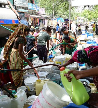 NEW DELHI, INDIA - 29 Mayıs 2024: Chanakyapuri 'deki JJ Cluster Vivekanand Kolonisi sakinleri 29 Mayıs 2024' te Yeni Delhi, Hindistan 'da bir tankerden su doldurdular. 