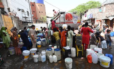 NEW DELHI, INDIA - 29 Mayıs 2024 'te Hindistan' ın Yeni Delhi kentindeki Sanjay Camp Chanakyapuri 'de yaz aylarında yaşanan bir su krizi sırasında, yerliler bir tankerden içme suyu alıyorlar. Artan sıcaklıkla Delhi büyük bir su kriziyle karşı karşıya. 