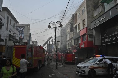 YENİ DELHI, INDIA - 20 Mayıs 2024 tarihinde Yeni Delhi, Hindistan 'da Ajmal Khan Yolu' ndaki bir galeride çıkan yangını kontrol etmeye çalışan Delhi itfaiye yetkilileri. Üst katta mahsur kalan üç kişi kurtarıldı, kıdemli bir polis memuru.