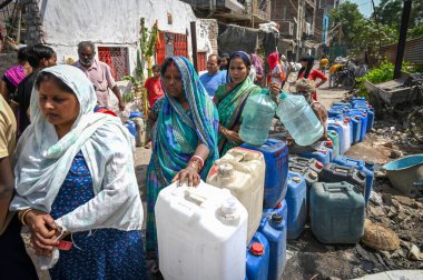 NEW DELHI, INDIA - 30 Mayıs 2024: 30 Mayıs 2024 'te Yeni Delhi, Hindistan' da Anand Parbat 'ta su krizi sırasında Delhi Jal Tahta Tankeri' nden su dolduran insanlar görüldü