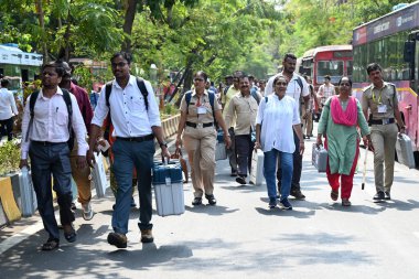 NAVI MUMBAI, INDIA - MAY 18, 2024: Election officials carry a (EVM) ballot box for distribution for constituency election scheduled on 20th May 2024 at Agri Koli Bhavan Nerul, on May 18, 2024 in Navi Mumbai, India. clipart