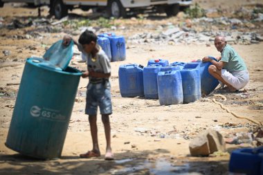 NEW DELHI, INDIA - 30 Mayıs 2024: 30 Mayıs 2024 'te Yeni Delhi, Hindistan' da Anand Parbat 'ta su krizi sırasında Delhi Jal Tahta Tankeri' nden su dolduran insanlar görüldü