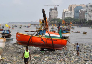 MUMBAI, INDIA - 27 Mayıs 2024 'te Hindistan' ın Mumbai kentindeki Badhwar Park 'ta, bir vinç kullanılarak deniz kıyısından çıkarılan bir tekne..