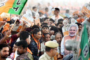 NEW DELHI, INDIA - 18 Mayıs 2024: Bharatiya Janata Partisi (BJP) destekçileri 18 Mayıs 2024 tarihinde Hindistan 'ın Yeni Delhi kentinde düzenlenen bir halk mitinginde Başbakan Narendra Modi' nin pankartlarını tutuyorlar.