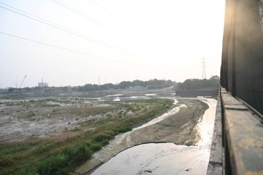 22 Mayıs 2024 'te Yeni Delhi, Hindistan' da Wazirabad, Kuzey Doğu Delhi 'de çöl ve düşük su seviyesi yamuna nehri manzarası. Delhi 'deki su krizi çoğunlukla Yamuna nehrindeki su seviyesinin azalmasından kaynaklanıyor.