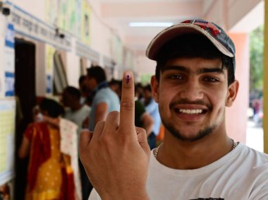 NEW DELHI, INDIA - 25 Mayıs 2024 'te Yeni Delhi, Hindistan' da ilk kez seçmen Ravi, Batı Delhi Lok Sabha Koltuğu 'ndaki Bharthal Dwarka köyünde mürekkepli parmağını gösteriyor.. 